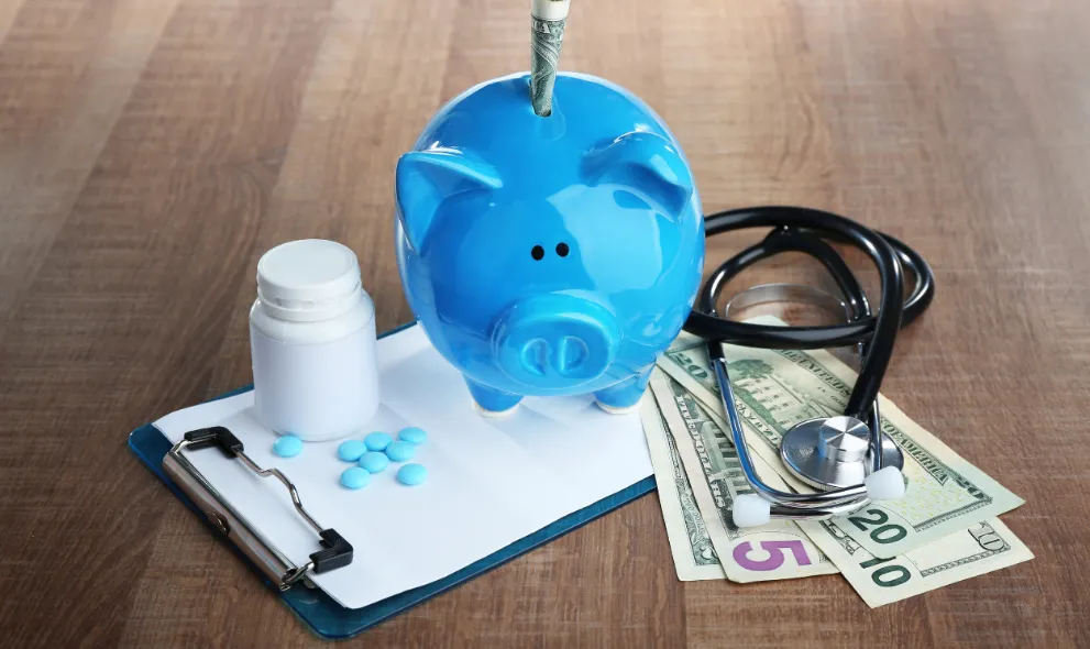 Blue piggy bank with stethoscope and medicine