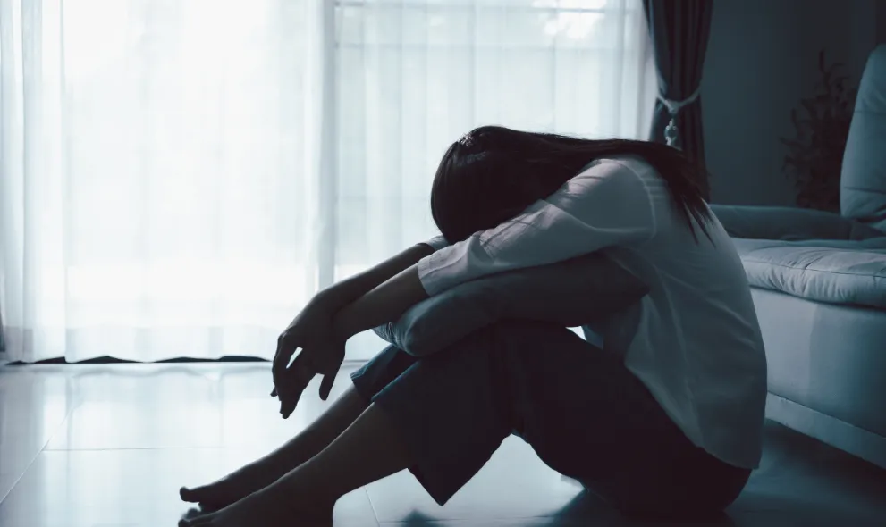 Depressed woman sitting on the floor