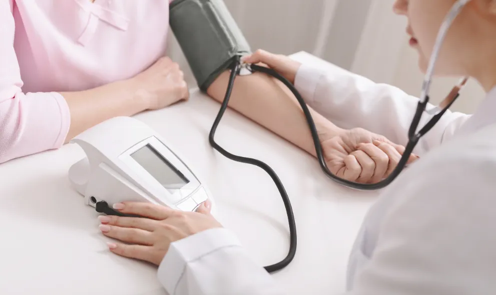 Doctor checking blood pressure of woman