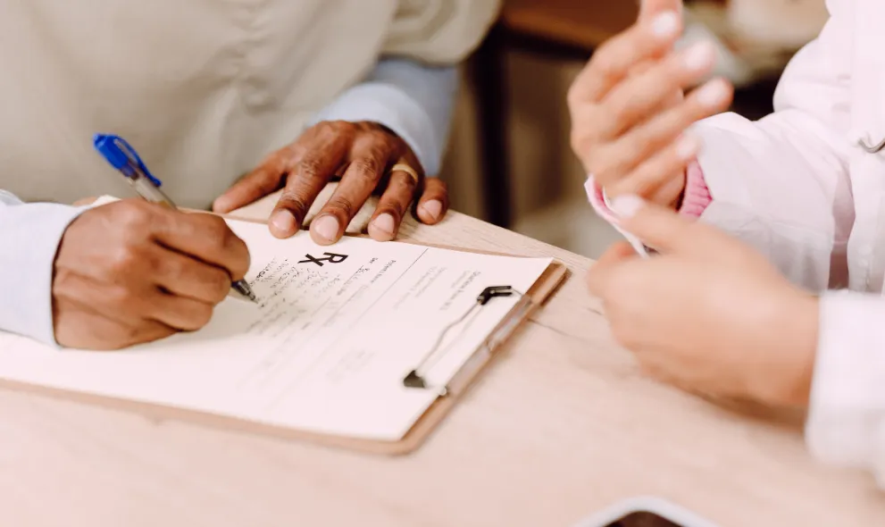 Doctor writing prescription for patient