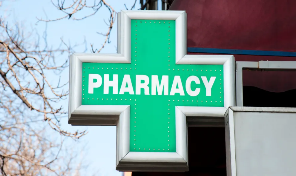 Green pharmacy sign on street