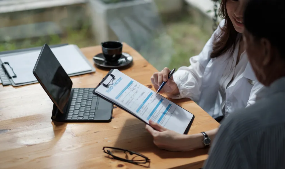 Insurance broker showing health insurance benefit to customer