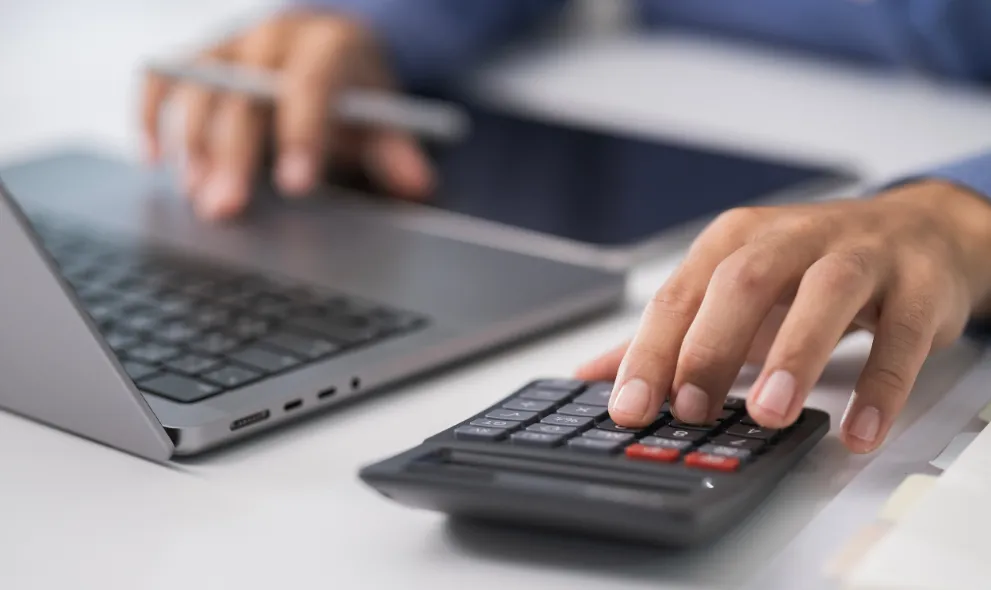 Person using a laptop and calculator
