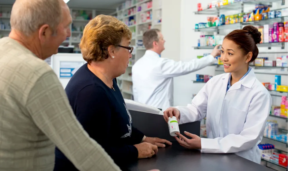 Pharmacist assisting senior couple