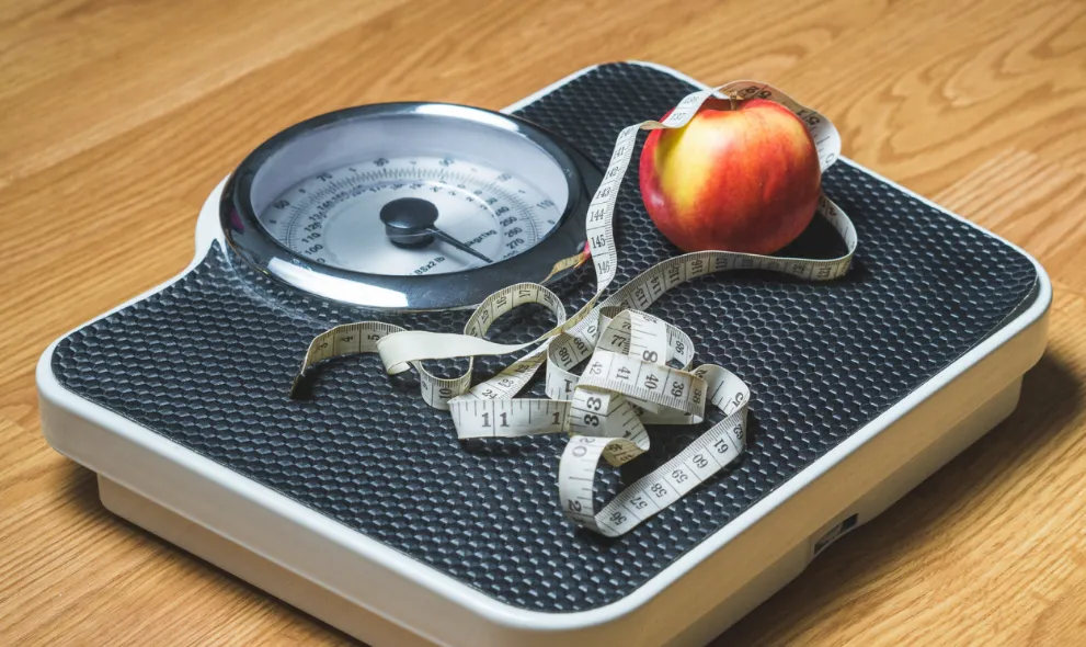 Scales with tape measure and apple