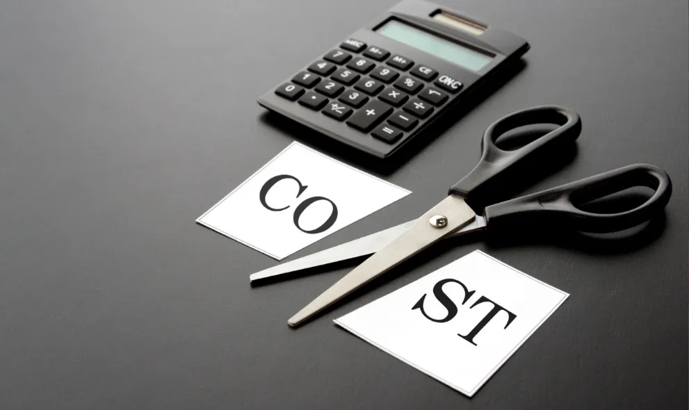 Scissors cutting through the text Cost with calculator