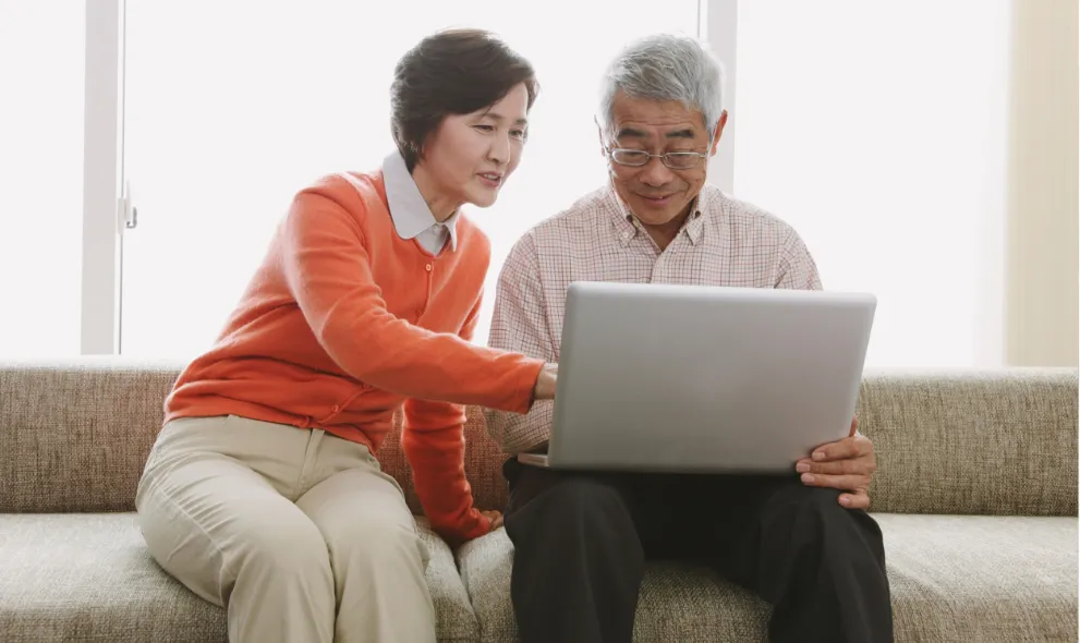 Senior couple looking on laptop