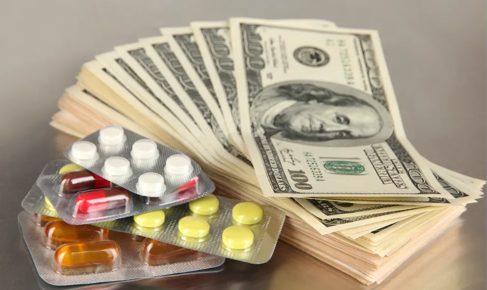 Stack of hundred dollar bills with medications