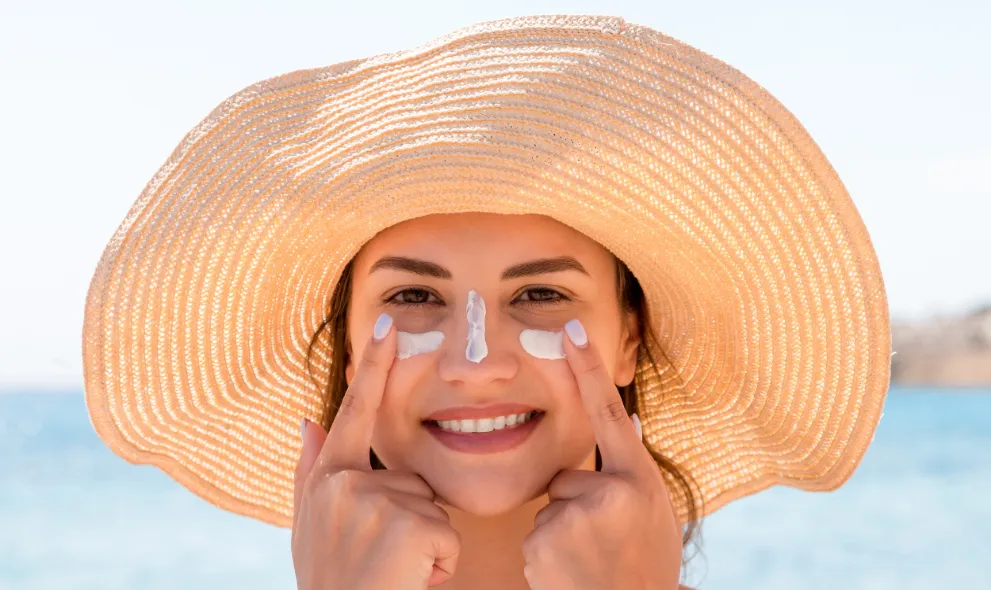 Woman applying sunscreen on face